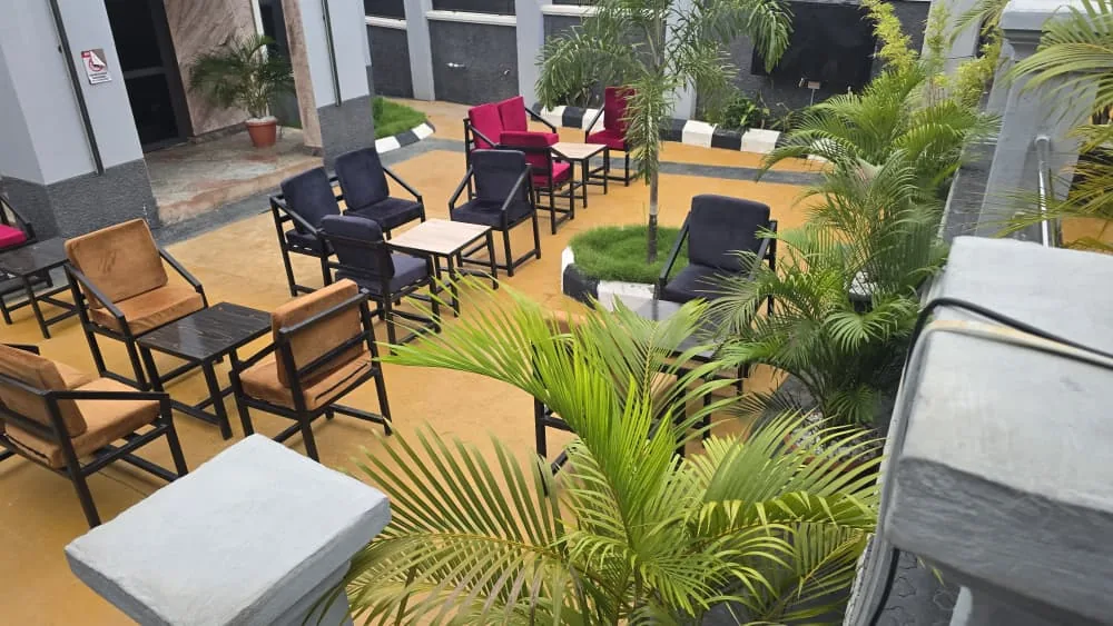 The garden at Dekroun Hub, laid out with chairs and low tables under the palms